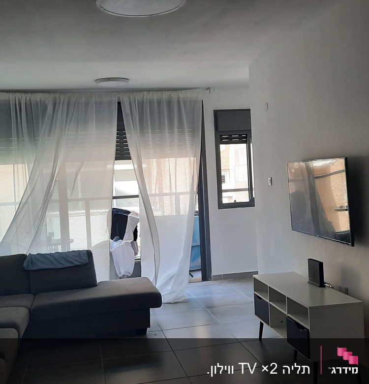 סלון עם ספה, טלוויזיה תלויה, וילון לבן